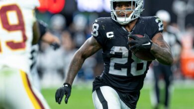 Josh Jacobs carries the ball in a Las Vegas Raiders uniform