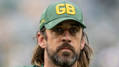 Aaron Rodgers wearing a Green Bay Packers cap on the sideline in 2021